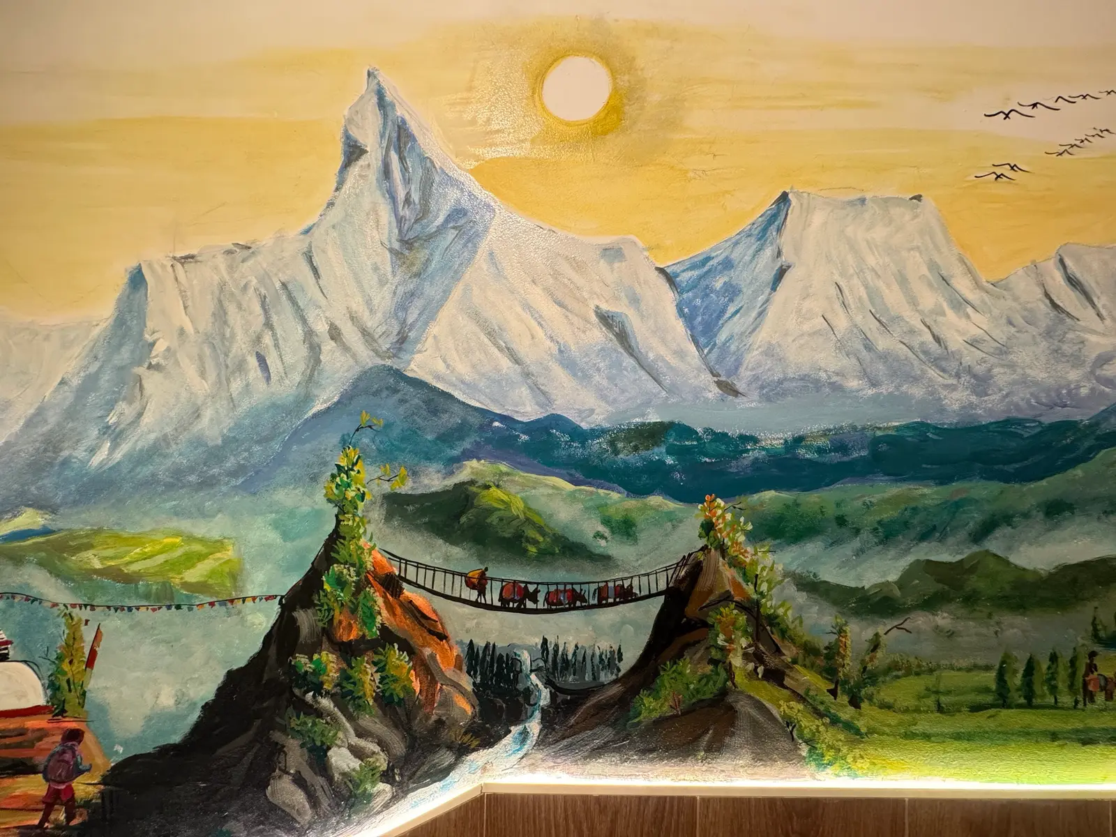 Painted Himalayan peaks under a pale sun, on our dining room wall