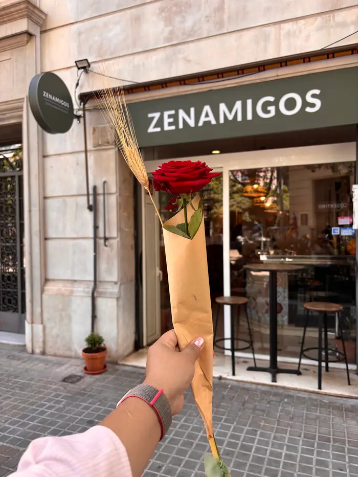 A Sant Jordi rose held up in front of the ZENAMIGOS sign