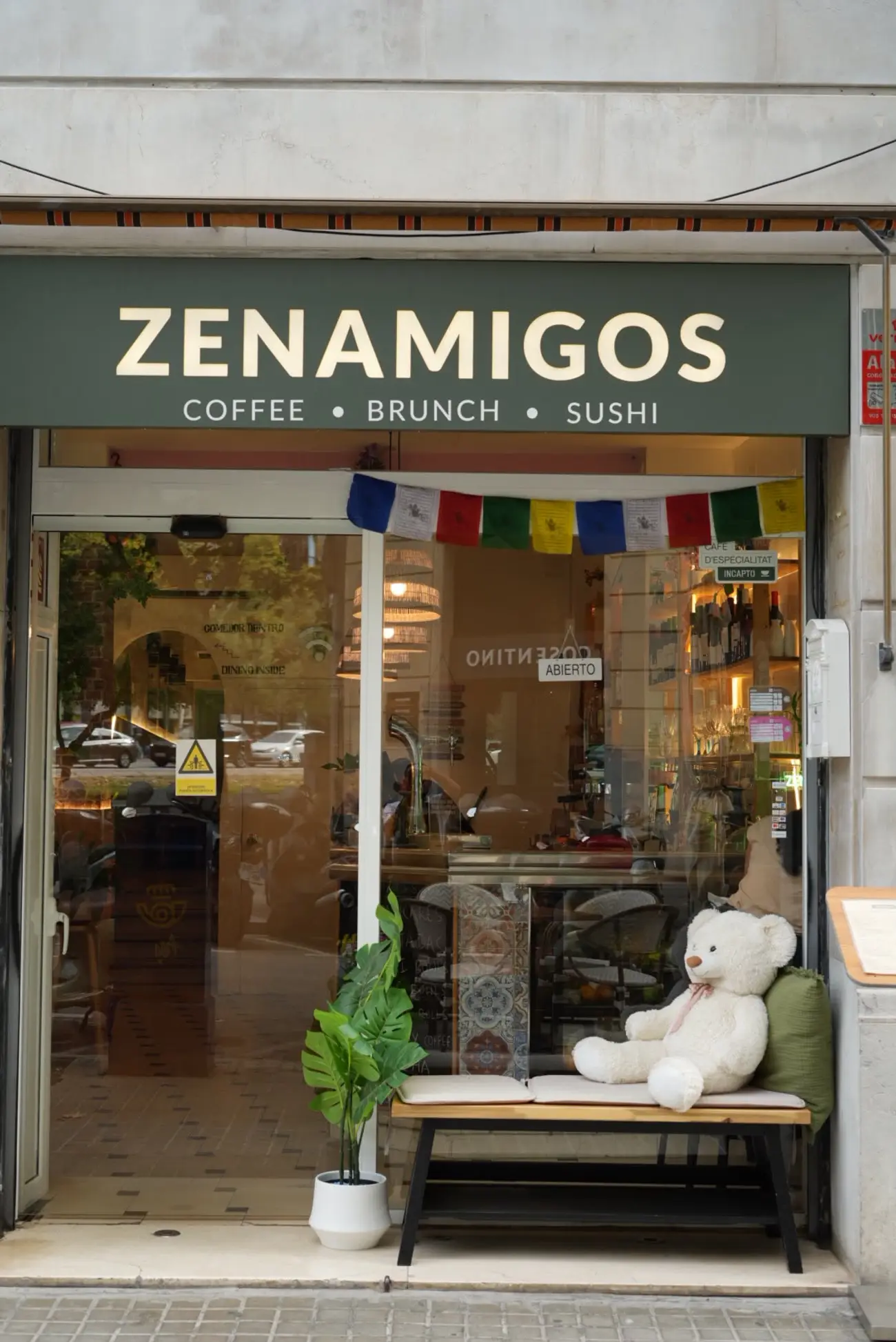 The ZENAMIGOS shopfront, with Nepali prayer flags over the door
