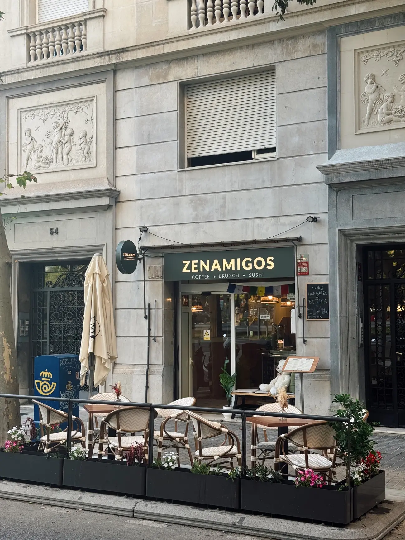 The ZENAMIGOS building on Carrer de Loreto, with the green sign and the terrace